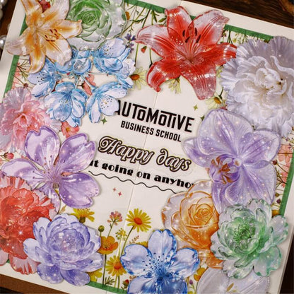 A square decorative card or print featuring a watercolor-style floral border with large flowers in red, purple, blue, pink, orange, and green around the edges. The center reads 'AUTOMOTIVE BUSINESS SCHOOL' and 'Happy days it going on anymo' on a white background.