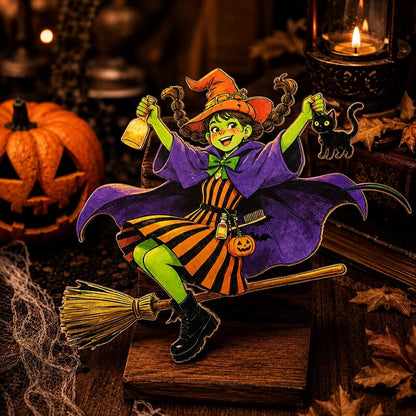 A Halloween-themed decorative figurine of a witch riding a broomstick, holding a cauldron and a small black cat, set against a dark, cozy autumn background with a pumpkin, books, and a candle.