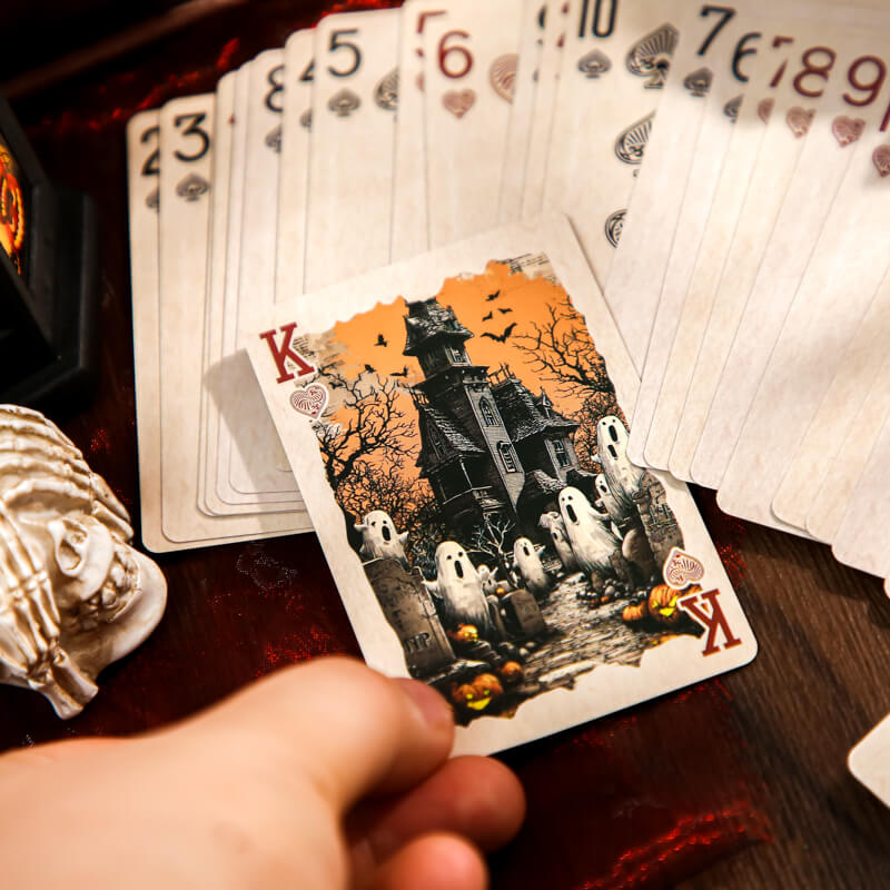HandholdingaHalloweenkingcardfeaturingahauntedhouseandghosts