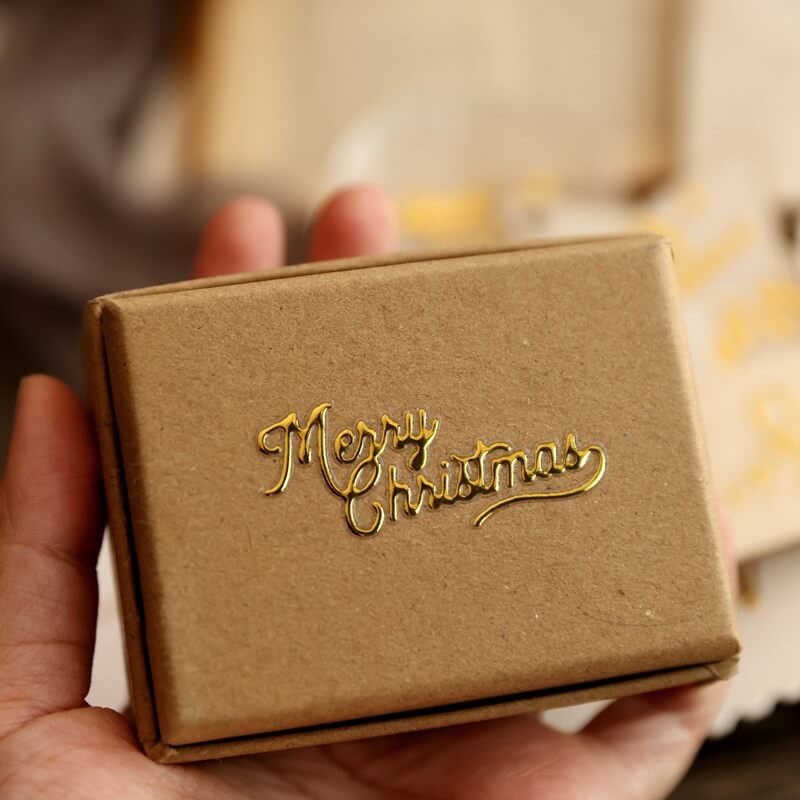 MerryChristmasgoldUVtransferstickerappliedtoakraftpapergiftbox