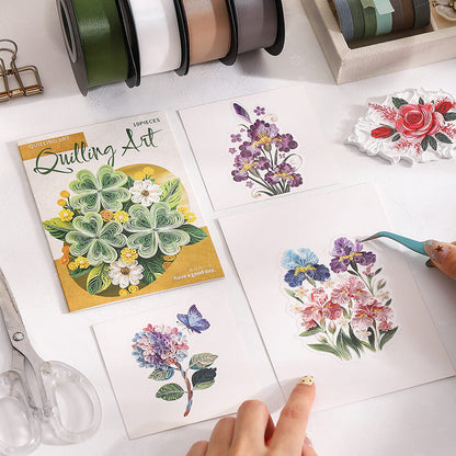 A styled flat-lay of floral sticker art supplies on a white surface, including four printed floral sticker sheets, a Quilling Art booklet, ribbon spools, scissors, and tweezers. A hand is placing a pink and purple flower sticker, with another hand holding a teal tool.