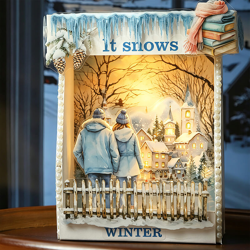 Winterscrapbookpagedecoratedwithasnowyvillage_couple_books_pinecones_and_ItSnows_lettering
